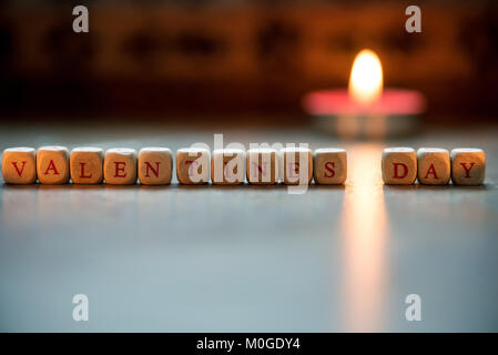 La parola felice il giorno di San Valentino di cubi di legno su un sfondo di legno. Foto Stock