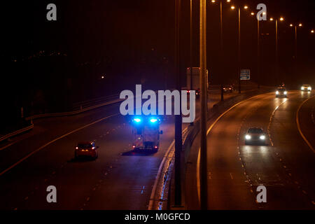 Ambulanza accelerando lungo l autostrada con luci blu lampeggiante in Irlanda del Nord Regno Unito Foto Stock