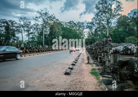 Turisti e il traffico sul ponte a South Gate, tempio Bayon, Angkor Thom, Cambogia. Foto Stock