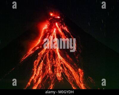 Legazpi, Albay, Filippine. Il 22 gennaio, 2018. Flussi di lava dal cono del vulcano Mayon lunedì sera, come visto da di Legazpi, a circa dodici chilometri dal vulcano. Ci sono stati una serie di eruzioni del vulcano Mayon vicino a Legazpi lunedì. Le eruzioni iniziato domenica notte e proseguita attraverso il giorno. Per mezzogiorno il vulcano ha inviato un pennacchio di fumo e cenere che domina Camalig, il comune più grande vicino al vulcano. L'Istituto filippino di vulcanologia e sismologia (PHIVOLCS) esteso i sei chilometri di zona di pericolo a otto chilometri e ha sollevato il livello di allerta da tre a Foto Stock