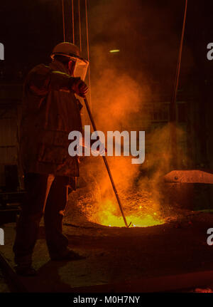 Fonderia di acciaio sul posto di lavoro con il lavoratore.Fusione di ferro.il concetto di settore. Foto Stock