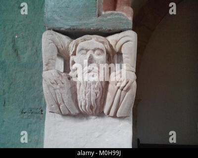 Una figura scultorea della capitale di Bücken, Germania, caratterizzata da sculture in pietra medievali caratteristiche dell'architettura romanica della chiesa. Foto Stock