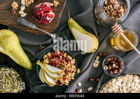 Vista superiore del granola ingredienti e ciotola con granola sul tavolo Foto Stock