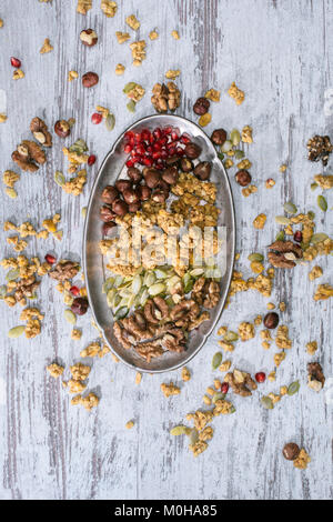 Vista superiore del granola ingredienti sulla piastra su un tavolo di legno Foto Stock