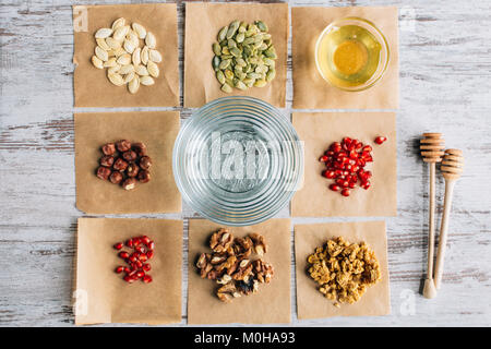 Vista superiore del granola ingredienti sulla carta da forno pezzi sul tavolo Foto Stock