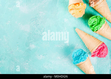 La selezione di vari luminoso multicolore di gelato in coni gelato al cioccolato - vaniglia Mirtillo Fragola pistacchio arancione, sulla luce di sole blu b Foto Stock