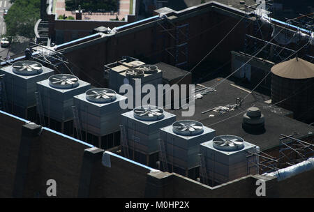 Le bocchette di scarico di industriali di condizionamento aria e unità di ventilazione su un grattacielo roof top in New York, Manhattan, come si vede dall'Empire State Buil Foto Stock