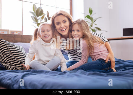 Felice madre e le sue figlie coccole Foto Stock