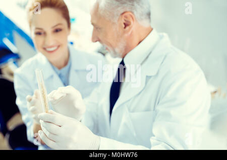 Lavoratori di laboratorio a discutere di campione di test in laboratorio Foto Stock