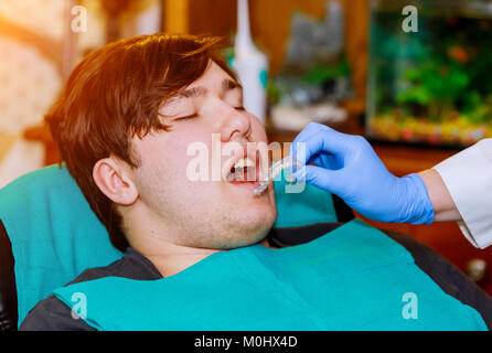 Close up di un dentista mano che mostra un impianto in un paziente in un ufficio dentista ortodontico dentale di silicone checkup Foto Stock