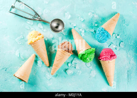 La selezione di vari luminoso multicolore di gelato in coni gelato al cioccolato - vaniglia Mirtillo Fragola pistacchio arancione, sulla luce di sole blu b Foto Stock