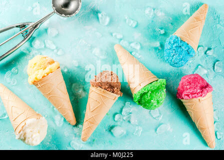 La selezione di vari luminoso multicolore di gelato in coni gelato al cioccolato - vaniglia Mirtillo Fragola pistacchio arancione, sulla luce di sole blu b Foto Stock