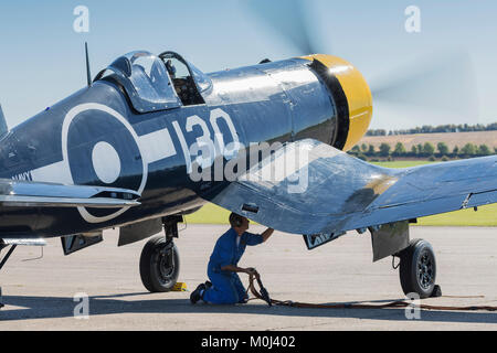 Goodyear Corsair FG-1D su aeromobili il grembiule con equipaggio a terra tecnico prima di volo il 22 settembre 2017 a Duxford, Cambridgeshire, Regno Unito Foto Stock