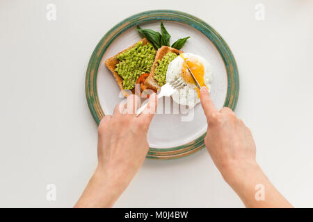 Uovo fritto e avocado su pane tostato Foto Stock