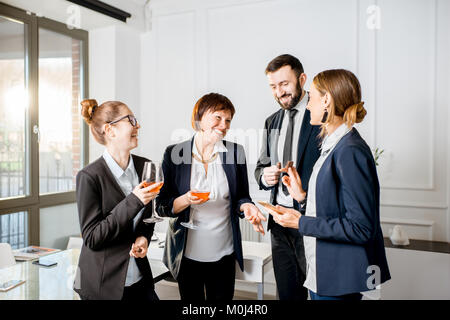 La gente di affari durante la riunione con bevande in ufficio Foto Stock