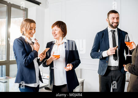 La gente di affari durante la riunione con bevande in ufficio Foto Stock