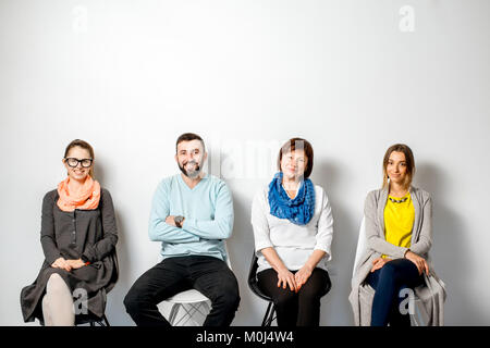 Persone in seduta informale in una riga Foto Stock