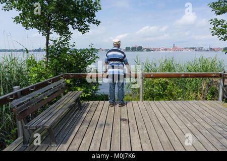 L uomo sta su una piattaforma presso il lago di Müritz, Waren, Lake District, Mecklenburg, Meclemburgo-Pomerania Occidentale, Germania, Europa Foto Stock