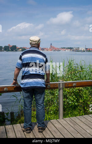 L uomo sta su una piattaforma presso il lago di Müritz, Waren, Lake District, Mecklenburg, Meclemburgo-Pomerania Occidentale, Germania, Europa Foto Stock