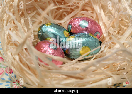 Lamina ricoperta di cioccolato Uova di Pasqua in un nido Foto Stock