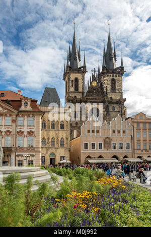 Un letto floreale attorno a una fontana con la Chiesa di Nostra Signora di Týn una chiesa gotica che domina la Piazza della Città Vecchia di Praga, Repubblica Ceca Foto Stock