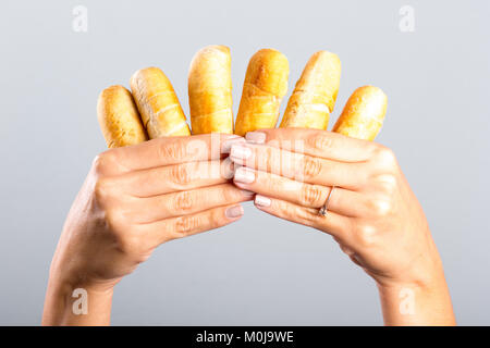 Donna di mano che tiene le dita di formaggio Foto Stock