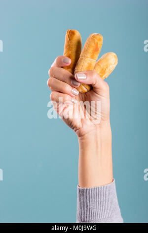 Donna di mano che tiene le dita di formaggio Foto Stock