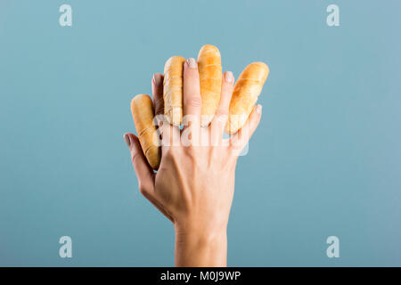 Donna di mano che tiene le dita di formaggio Foto Stock