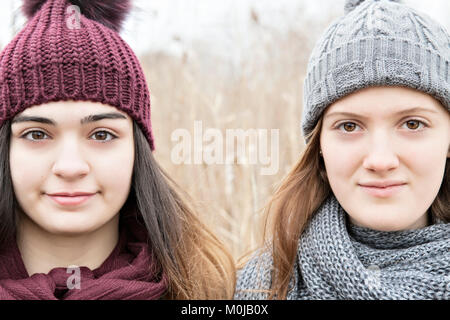 Due ragazze adolescenti in maglia da indossare cappelli e sciarpe e guardando la telecamera; Scarborough, Ontario, Canada Foto Stock