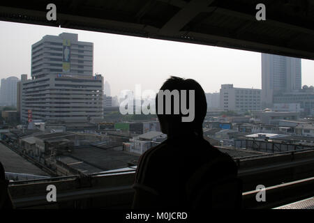 Affacciato sul centro di Bangkok da Siam BTS sky train station, Thai boy sta cercando attraverso la Bangkok urban skyline da Siam BTS sky train station Foto Stock