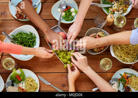 Gruppo di persone mangiare a tavola con i prodotti alimentari Foto Stock