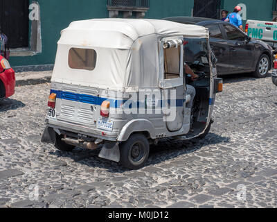 A TRE RUOTE Tuk Tuk Taxi con la guida del tetto in Antigua Guatemala America Centrale Foto Stock