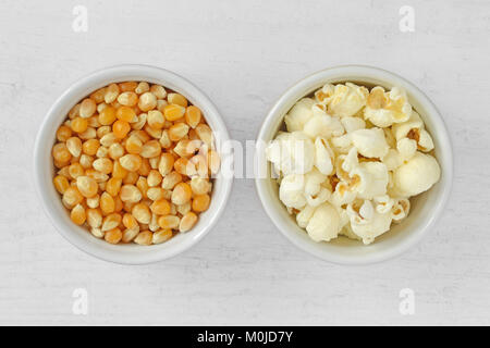 Essiccato di chicchi di mais e pop corn in ciotole su sfondo di legno Foto Stock