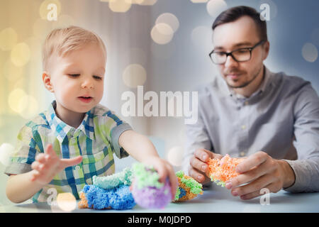 Padre e figlio giocare con argilla a sfera a casa Foto Stock