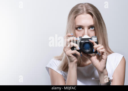 Giovane bella donna di scattare una foto con una fotocamera retrò Foto Stock