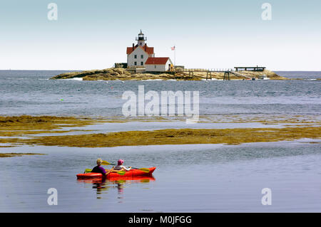 Un kayaker lungo la costa del Maine con il faro Cuckholds (restaurata) in background, STATI UNITI D'AMERICA Foto Stock