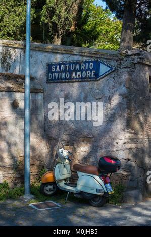 Roma, Italia. Vespa parcheggiata e 'Santuario Divino Amore' street segno. via Appia Antica. Foto Stock