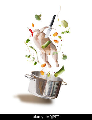 Flying materie del brodo di pollo ,bouillon o gli ingredienti della zuppa di pollo intero, verdura,il condimento, il coltello e la pentola di cottura, vista frontale, isolato su bianco Foto Stock