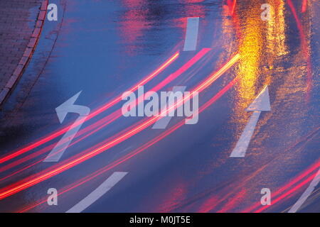 Pioggia-strada bagnata, luci, frecce di direzione sotto la pioggia al tramonto, Brema, Germania Foto Stock