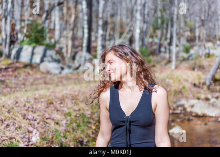 Primo piano del profilo laterale Ritratto di giovane donna felice volto sorridente nel soleggiato autunno marrone, caduta, d'estate il parco, fiume flusso di acqua dalla natura della foresta Foto Stock