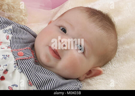 3 mese fa bambina posa su una coperta Foto Stock