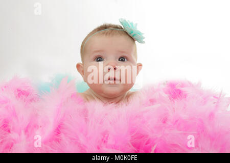 3 mese fa bambina posa in mucchio di piume Foto Stock