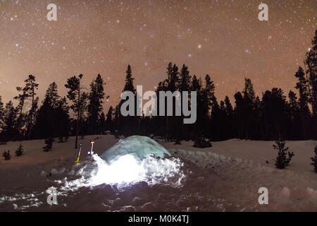 La Via Lattea costellazione di stelle siede nel cielo notturno su un campeggio nevoso presso il Parco Nazionale di Yellowstone in inverno 11 gennaio 2018 in Wyoming. Foto Stock