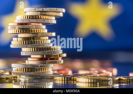 Euro money.Euro Flag.valuta Euro.monete impilate le une sopra le altre in diverse posizioni. Bandiera dell'Unione europea. Foto Stock