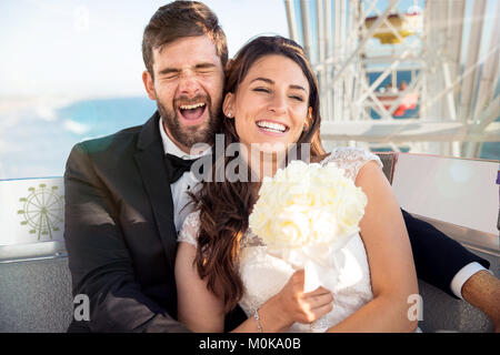 Divertimento carino sposa e lo sposo godendo di uno stile di vita per la luna di miele matrimonio sulla ruota panoramica Ferris Foto Stock