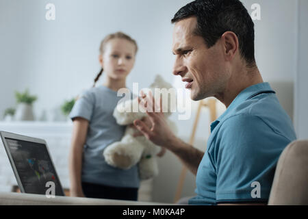 Occupato uomo al lavoro e non avendo il tempo sulla riproduzione Foto Stock