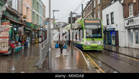 Una signora anziana veicoli pesanti sacchetti di plastica avendo avuto un tram su Croydon, a sud di Londra. Foto Stock