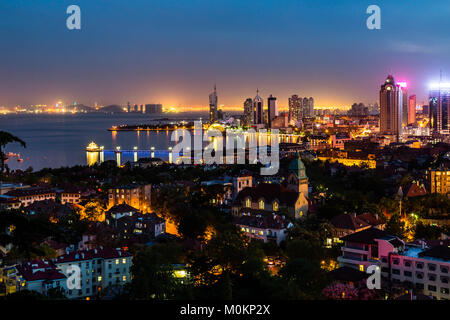 La baia di Qingdao e la chiesa luterana visto dalla collina del parco di segnale di notte, Qingdao, Cina Foto Stock