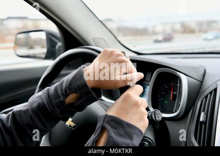 Le mani sul volante di un automobile Foto Stock