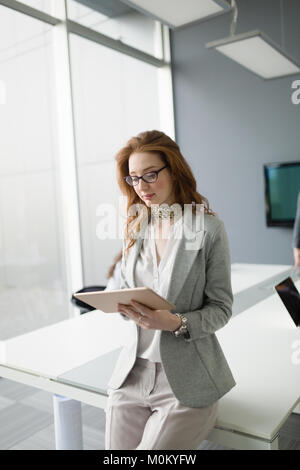 Malinconici business donna azienda tablet in ufficio Foto Stock